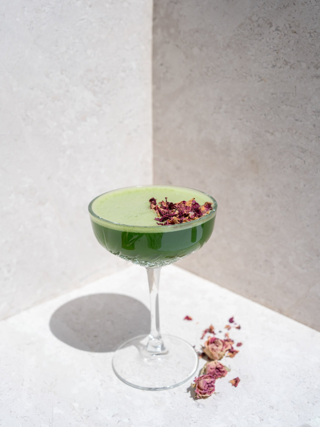 Iced Matcha in einem Cocktailglas mit Trockenblumen