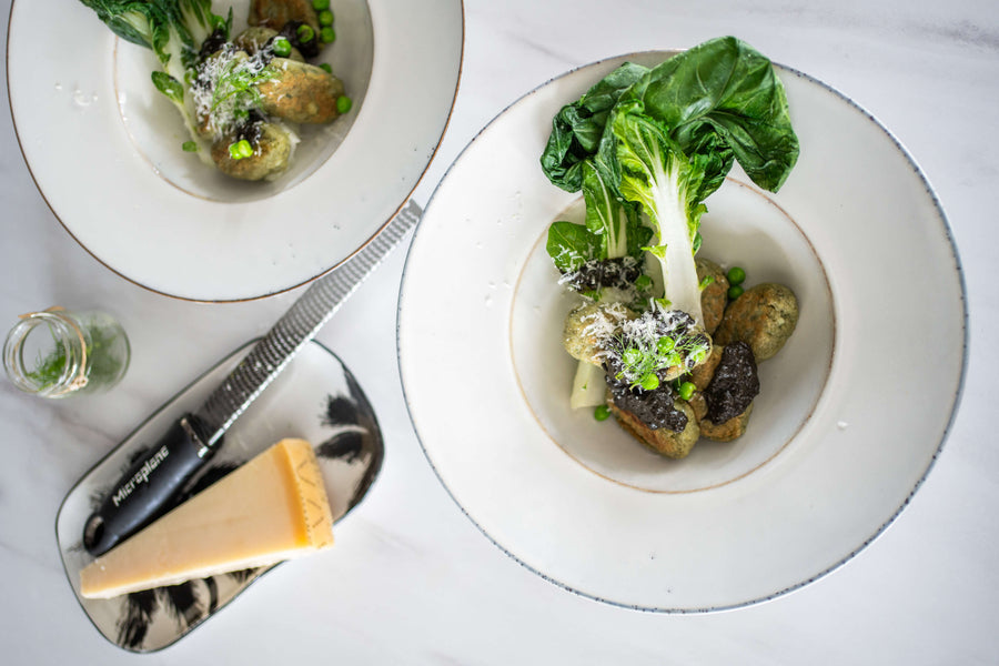 Grüne Matcha Gnocchi mit Miso-Buttersauce, Pak Choi und Erbsen auf einem Teller