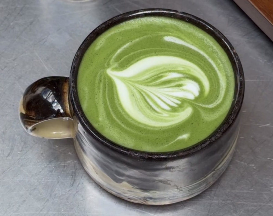 Warmer Matcha Latte in einer Keramikschale, mit Latte Art in der grünen Schaumschicht